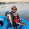Father and son show off their catch of largemouth bass at the lake Picachos.