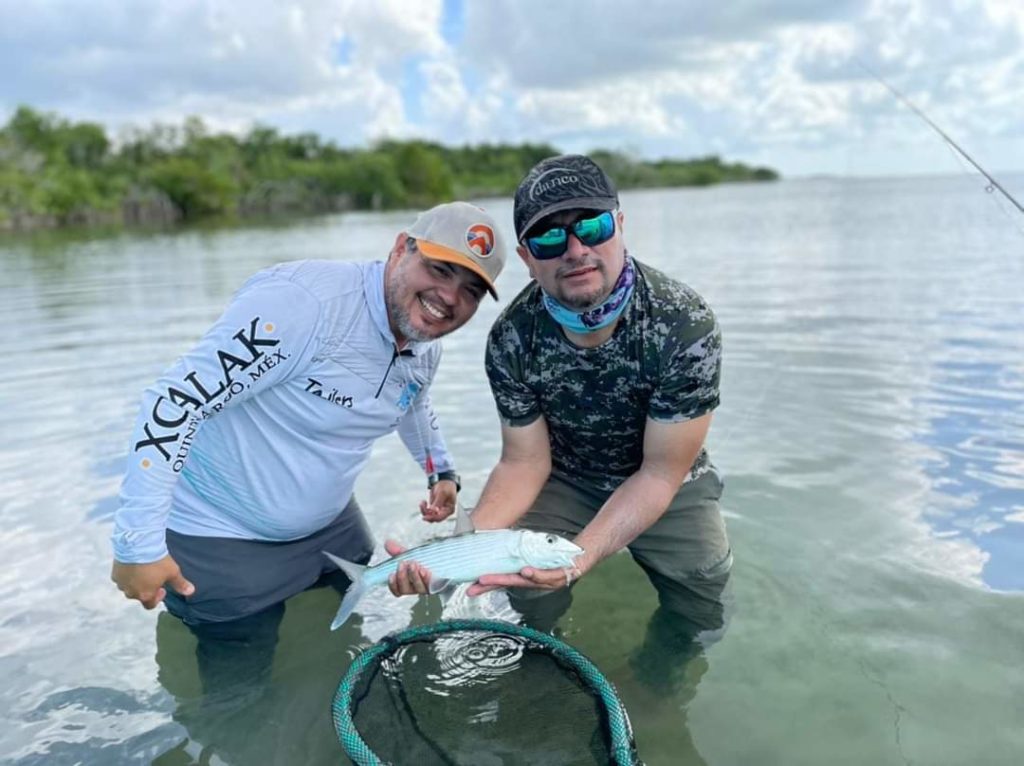 Anglers showing off a baby tarpon caught in chetumal mexico