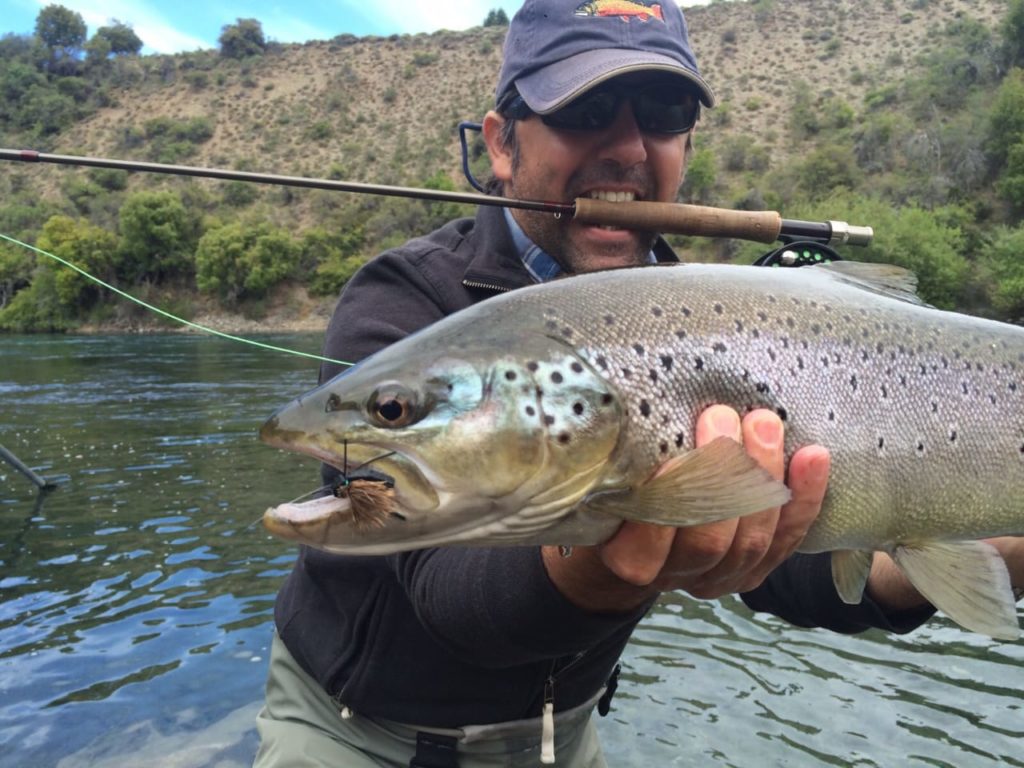 Pescador con trucha marrón Argentina